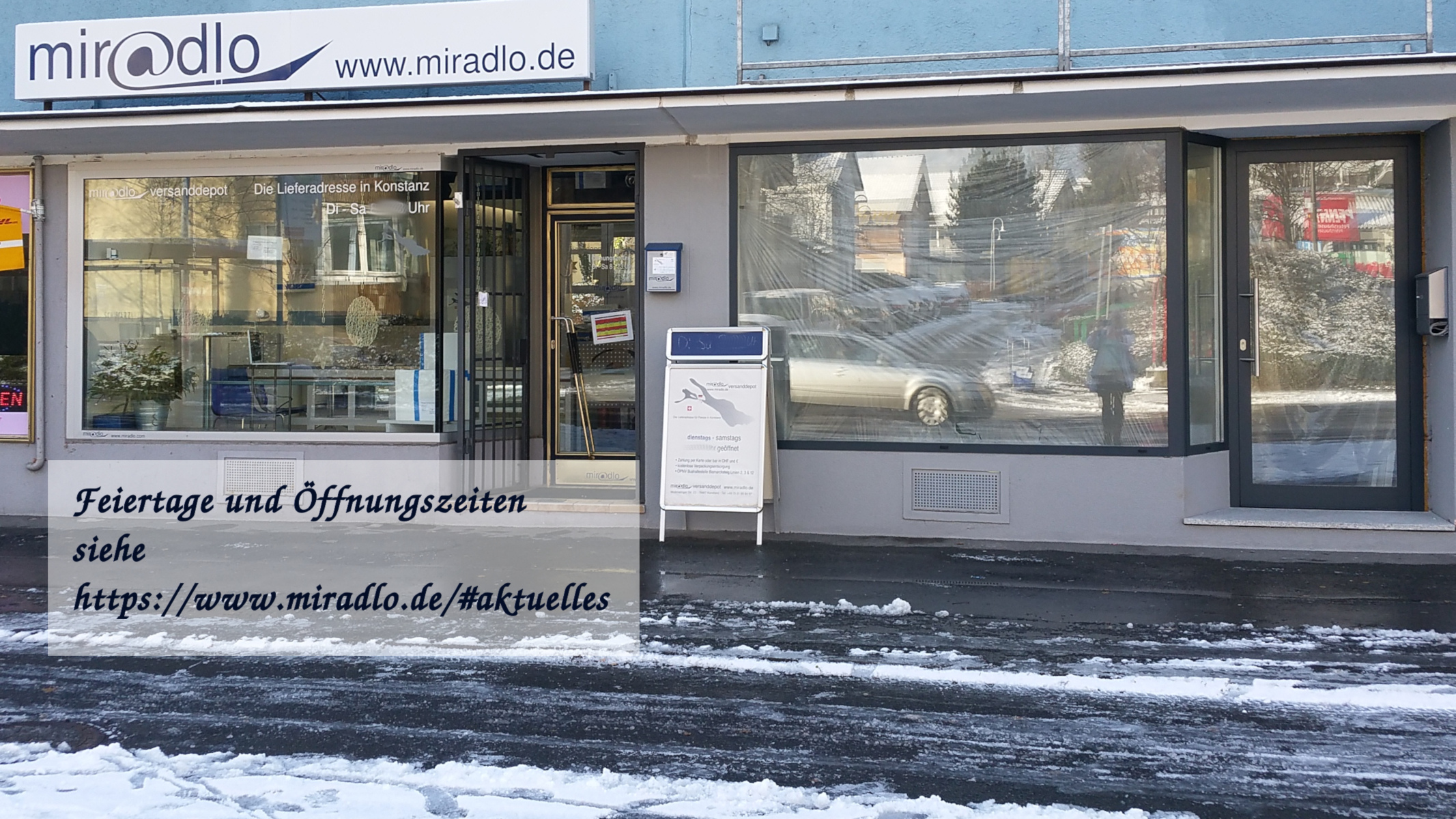 Schaufenster miradlo Versanddepot mit etwas Schnee und Öffnungszeiten-Infos