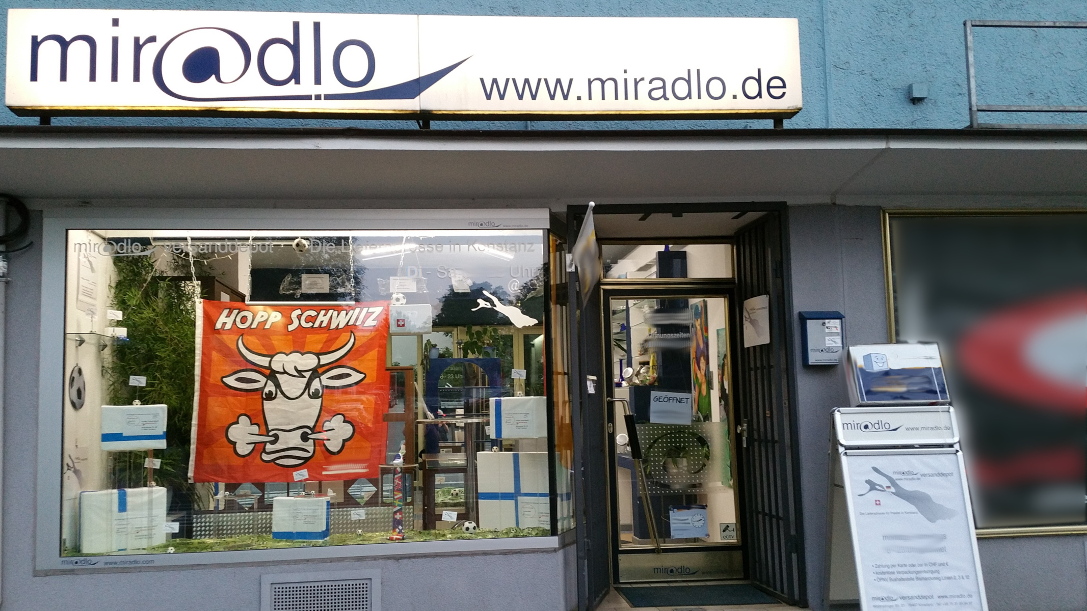 miradlo-Versanddepot Konstanz, Schaufenster mit Fußballdeko und Hopp-Schwiiz-Fahne